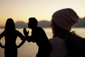Donna al tramonto e sagome di un uomo che chiede scusa a una donna