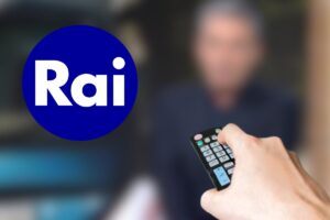 Logo Rai. mano con telecomando e nello sfondo programma tv